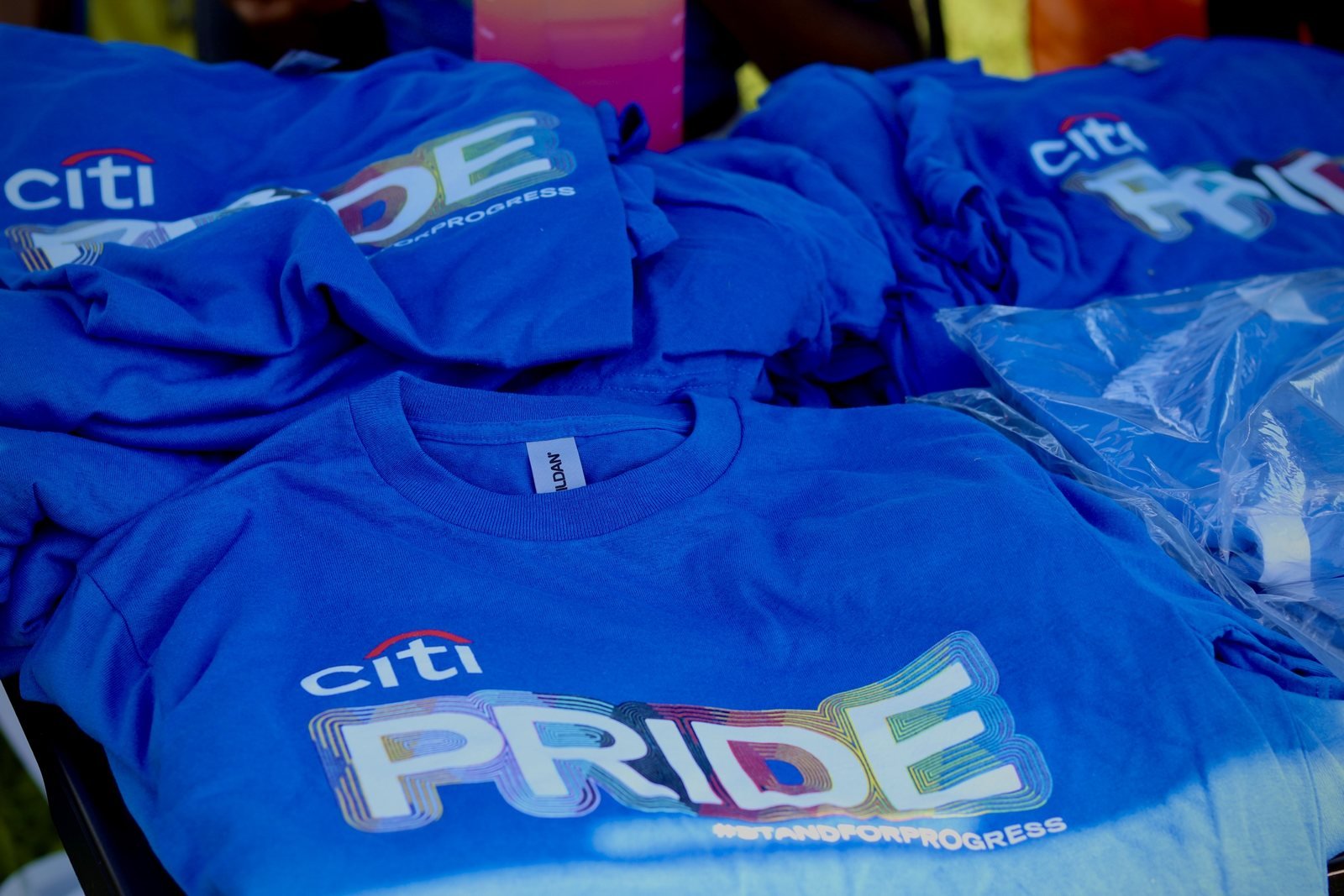 Folded blue Pride team shirts on a table