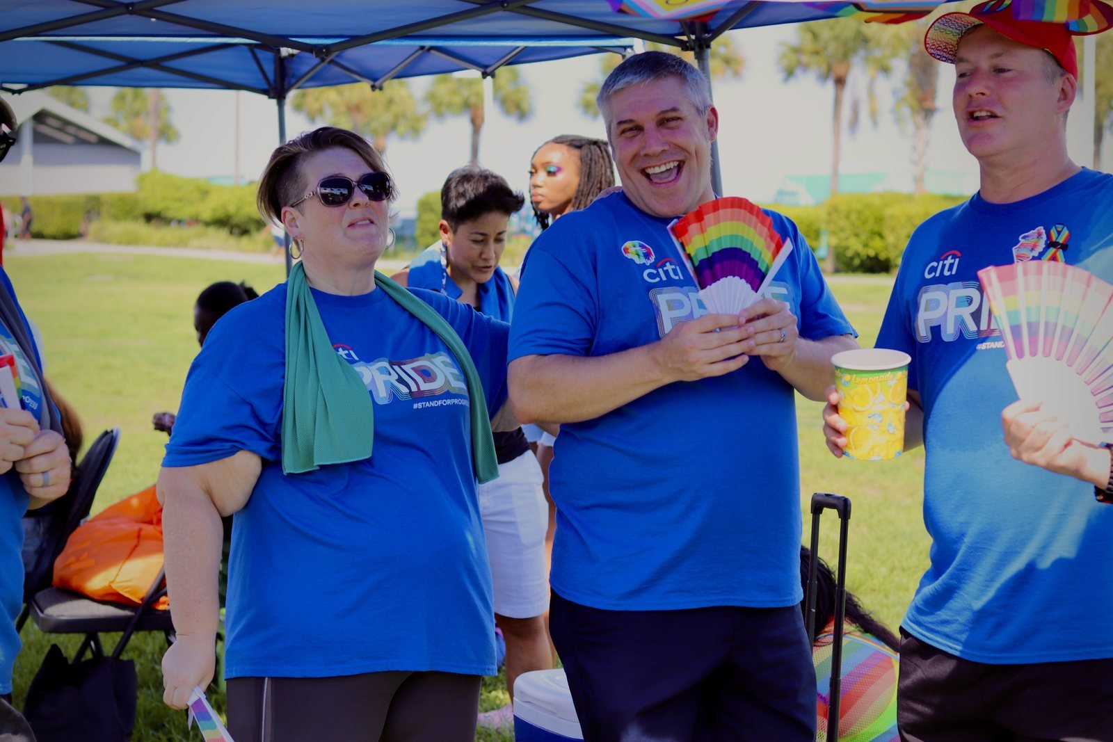 Team members laughing together with rainbow fans and lemonade