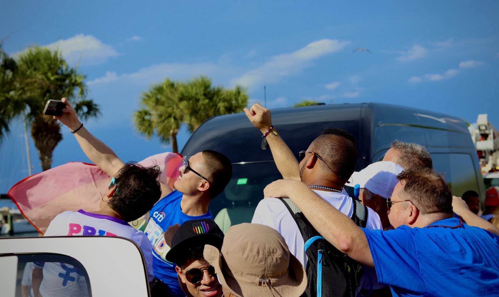 Marchers taking a selfie with a raised fist under a blue sky