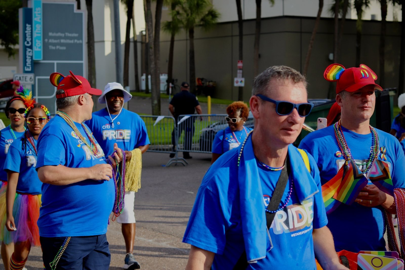 Marchers in blue team shirts handing out beads along the parade route