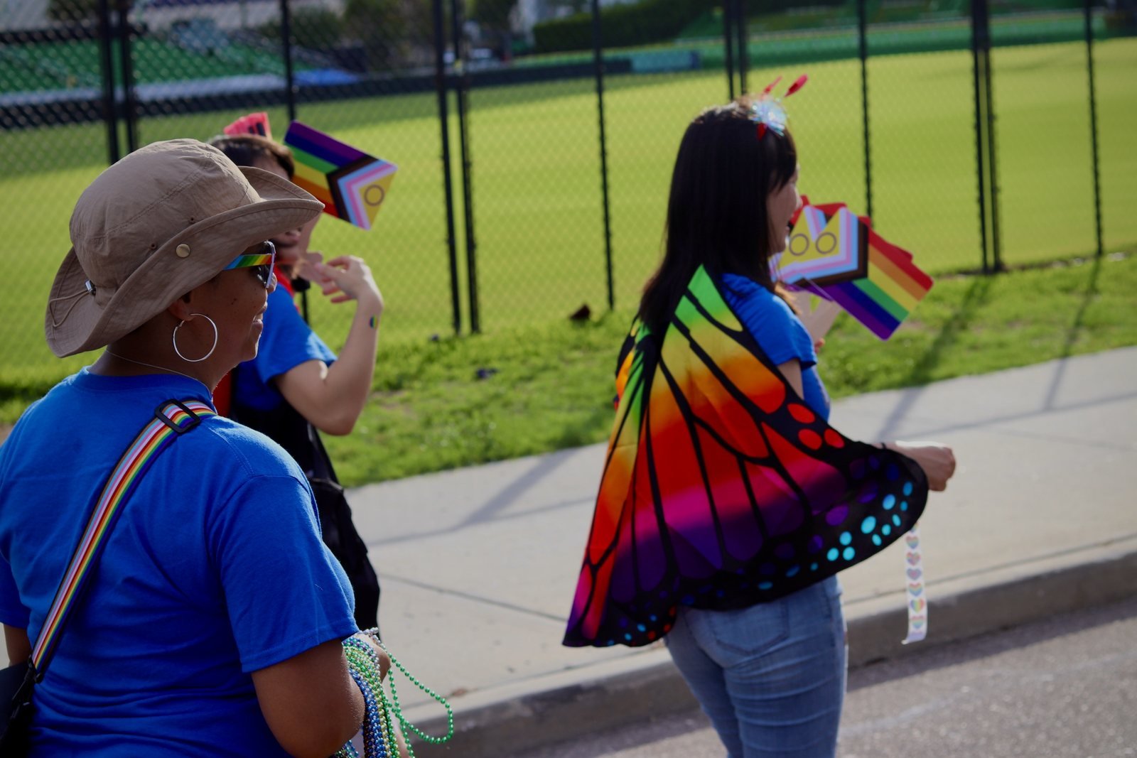 Marcher wearing rainbow butterfly wings and carrying flags
