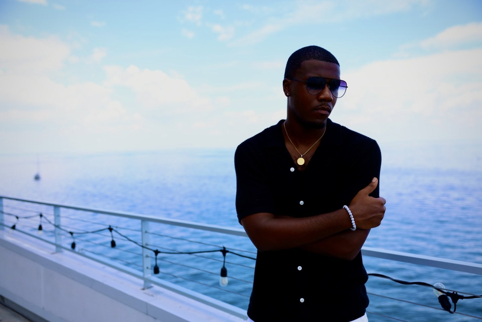 Man in a black shirt posed on an ocean terrace