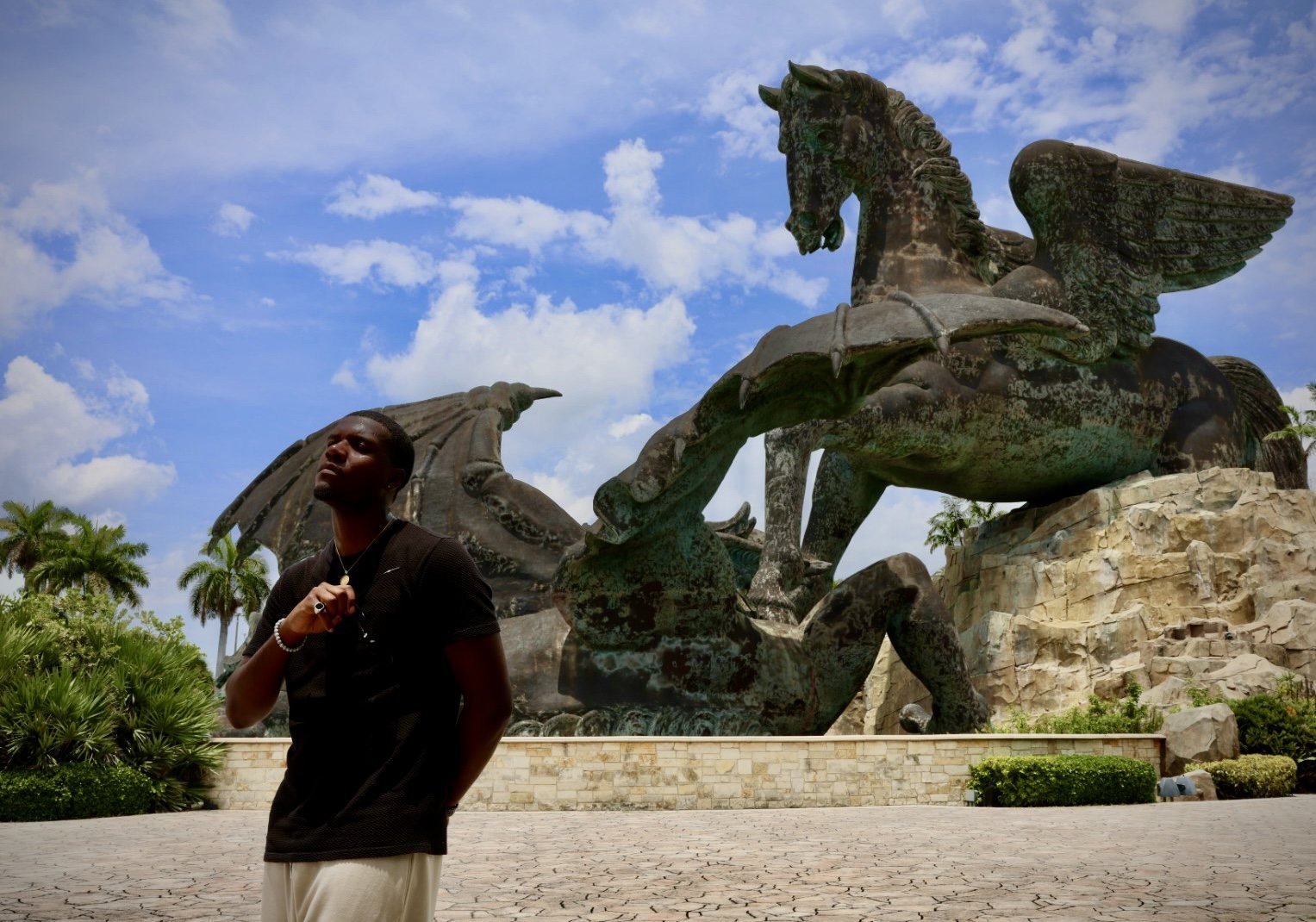Man standing beneath a Pegasus sculpture