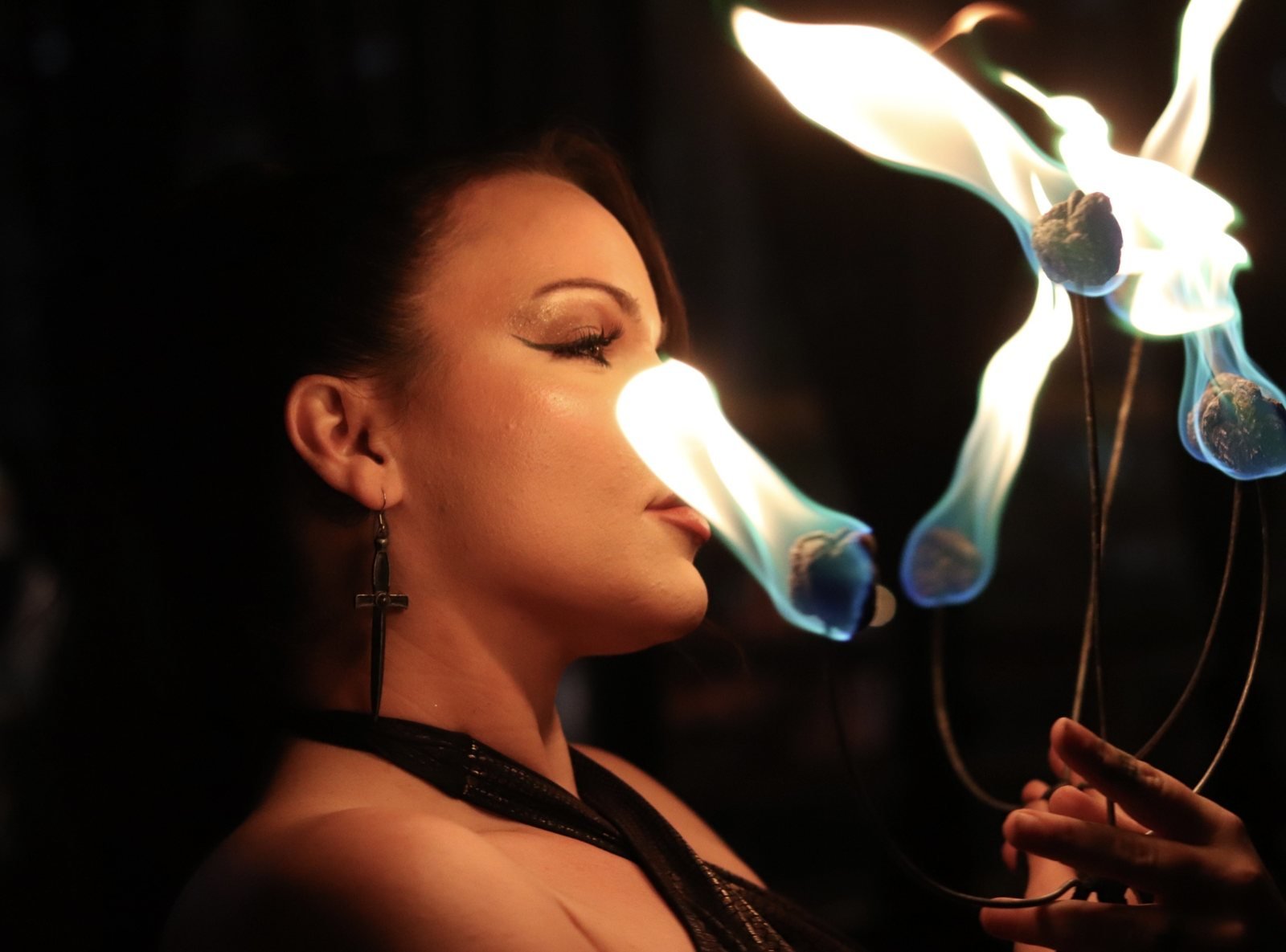 Woman in profile holding a flame
