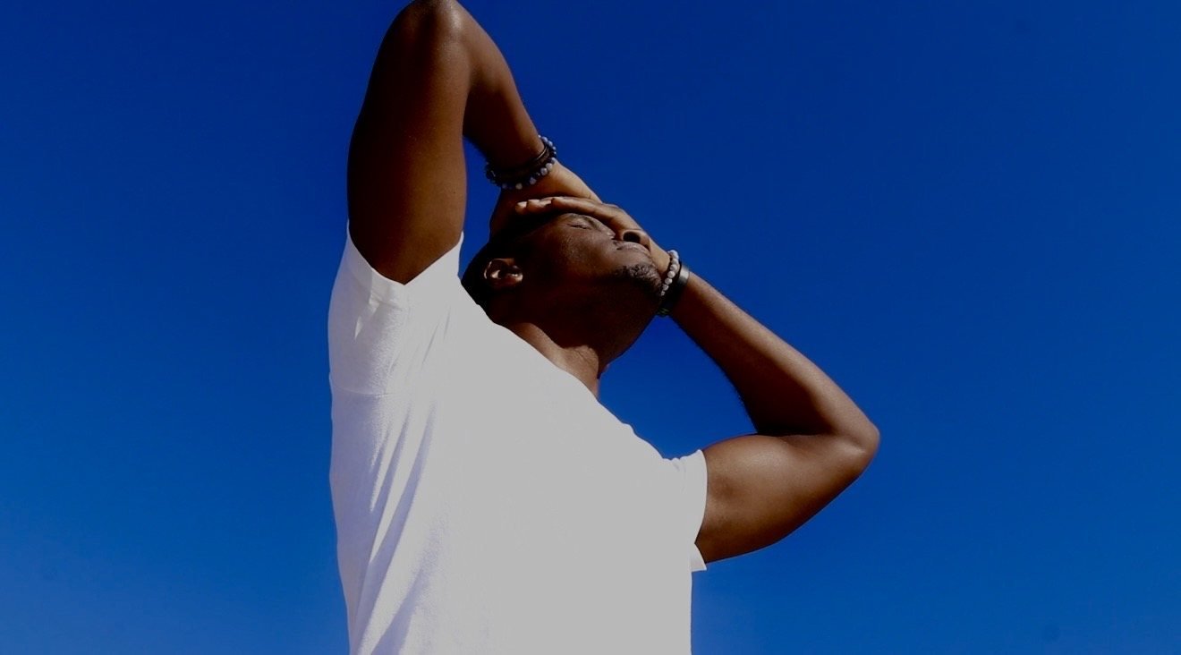 Man in a white shirt posed against a blue sky